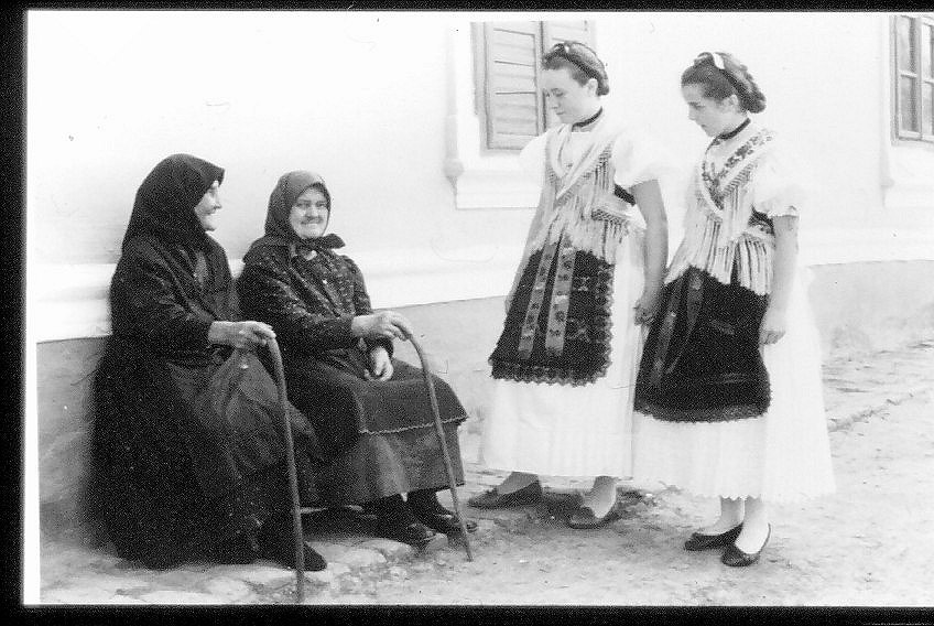 Trachtenmaedchen mit alten Frauen